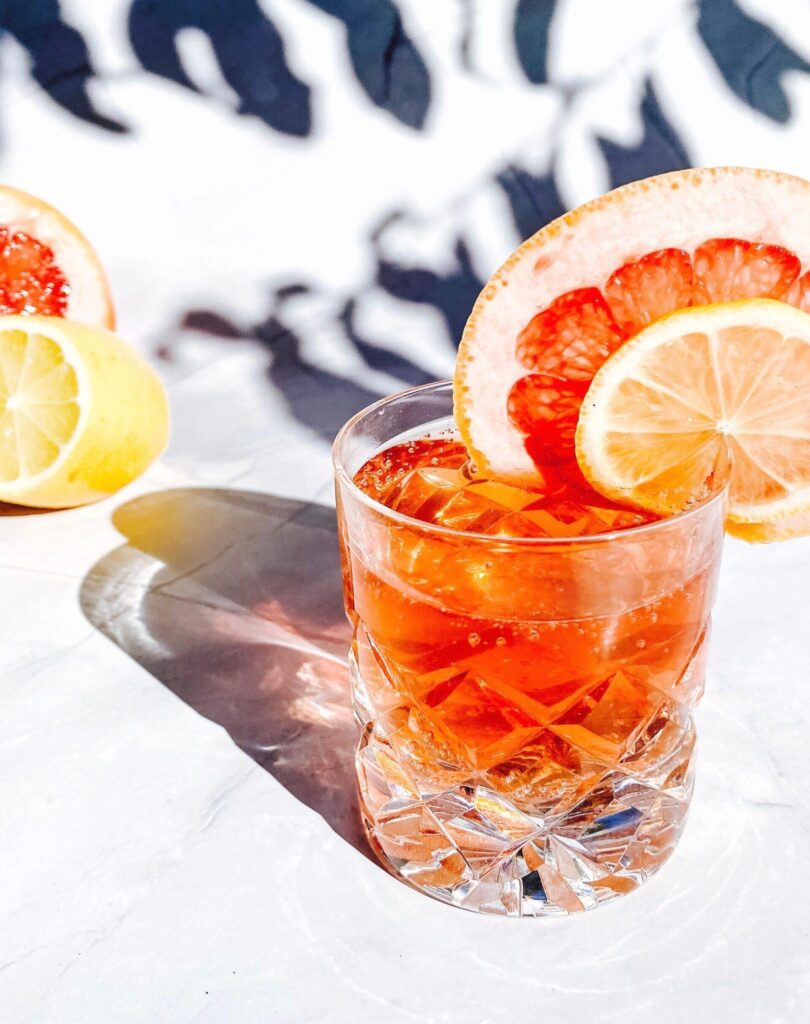 Bright citrus cocktail with grapefruit and lemon slices in crystal glass, perfect for summer.